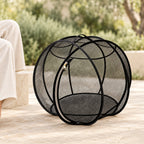 Black Cat Explorer Sphere on a shaded, level patio beside a seated adult; intended for supervised exploration.