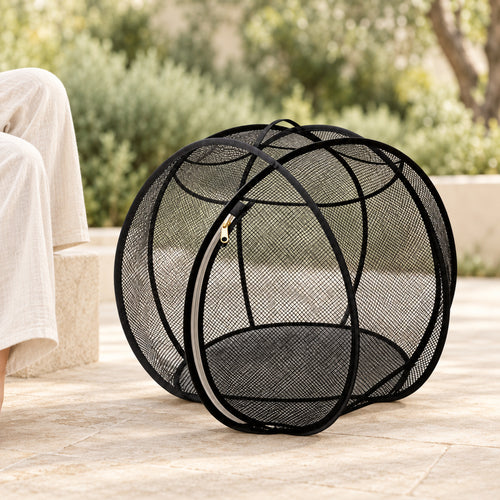 Black Cat Explorer Sphere on a shaded, level patio beside a seated adult; intended for supervised exploration.